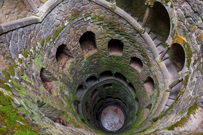 Der spiralartig in die Tiefe führende Steinturm, der „Initationsbrunnen“ in der Gartenanlage der Quinta da Regaleira. Hierher führen nur unterirdische Gänge bzw. ein im Fels versteckter Eingang. 