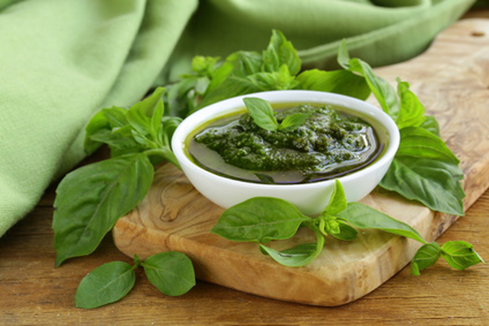 pesto sauce with basil and olive oil on a wooden table